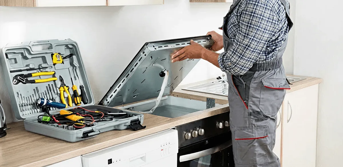 Handyman repairing a cooktop and checking wiring connections in Atlanta, GA
